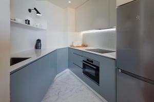 a kitchen with white cabinets and a refrigerator at ATeRIAN MUSKARIA in Zarautz
