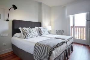 a bedroom with a large bed with a large window at ATeRIAN MUSKARIA in Zarautz