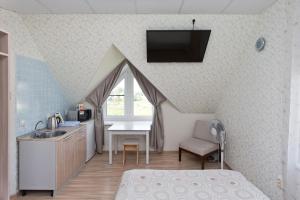 a room with a bed and a sink and a kitchen at Guest House Tri Klena in Velikiy Novgorod