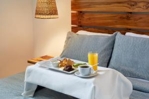 - une table avec un plateau de nourriture et un verre de jus d'orange dans l'établissement Villavela Hotel Boutique, à Sonsonate