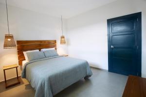 a bedroom with a bed and a blue door at Villavela Hotel Boutique in Sonsonate