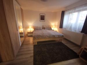 a bedroom with a bed and a window and a rug at Szent Erzsébet Apartmanház in Kecskemét