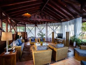 a living room with couches and chairs and a television at Coconut's Maresias Hotel in Maresias