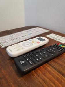 two remote controls sitting on top of a wooden table at La Familia in San Blas