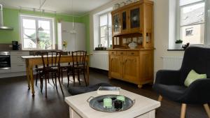 kuchnia i salon ze stołem i krzesłami w obiekcie Ferienhaus Alte Schule w mieście Volkesfeld
