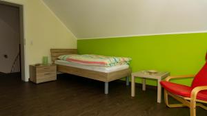 a bedroom with a bed and a green wall at Ferienhaus Alte Schule in Volkesfeld