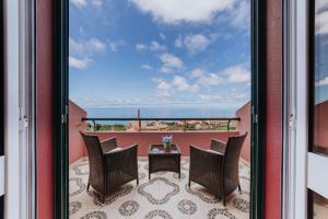 a view from a balcony with chairs and a table at Villa Amore Accommodation in Paul do Mar