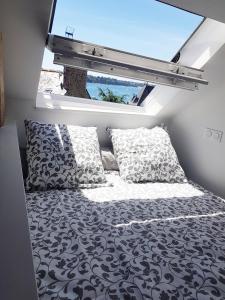 a bed in a small room with a window at Logement entier Saint Malo vue mer, proche FERRY, commerces et plage Solidor 50 m in Saint Malo