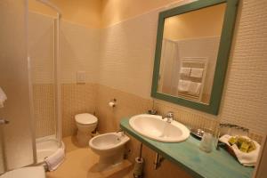 a bathroom with a sink and a toilet and a mirror at Agriturismo Peretti in Fonteblanda