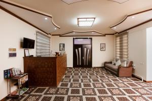 a living room with a couch and a television at Xurshidabonu Guest House in Khiva