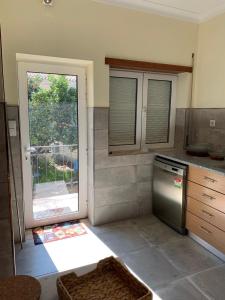Il comprend une cuisine équipée d'un réfrigérateur et d'une fenêtre. dans l'établissement Casa da Fonte, à Seia