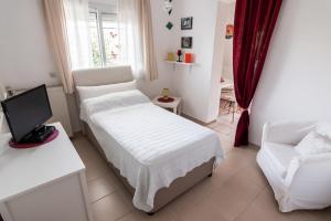 1 dormitorio con cama, sofá y TV en Anthos Apartments, en Limenas