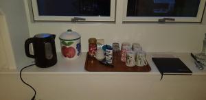 a counter top with a coffee maker and a tray with cups at Tjørnely in Østervrå