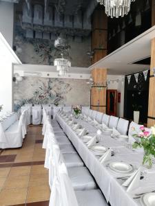 ノベ・ミアスト・ルバフスキエにあるHotel Tiffanyの白いテーブルと白い椅子が備わる宴会場