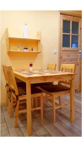 een houten tafel met twee stoelen en een tafel en planken bij Apartament Grota in Szklarska Poręba