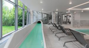 an indoor swimming pool with chairs and a slide at Residence Inn by Marriott Halifax Dartmouth in Halifax