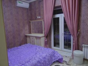 1 dormitorio con cama morada y ventana en Апартаменты Registan, en Samarkand
