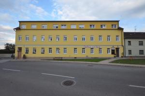 um grande edifício amarelo no lado de uma rua em Wartmannstetterhof em Wartmannstetten