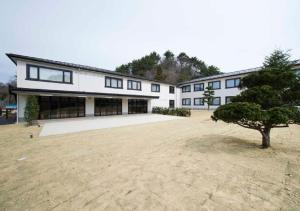 a large white building with a tree in front of it at Higashimatsushima - Hotel / Vacation STAY 43094 in Higashimatsushima