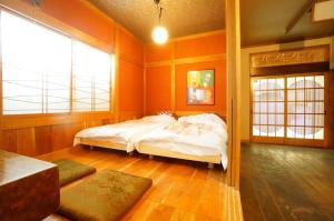 een slaapkamer met een bed in een kamer met oranje muren bij Private House IT / Vacation STAY 47911 in Takayama