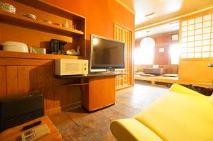 a living room with a television and a couch at Private House IT / Vacation STAY 47911 in Takayama