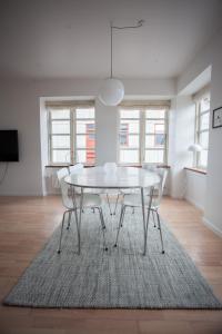 un comedor blanco con una mesa y sillas blancas en Central apartment in Tórshavn, en Tórshavn