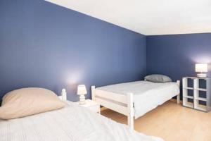 a bedroom with two beds and a blue wall at beau meublé centre historique in Bordeaux