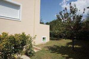 a white building with a window on the side of it at Christinas garden in Patra