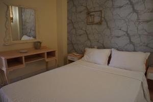 a bedroom with a white bed and a mirror at Christinas garden in Patra