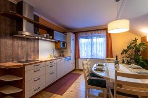 a kitchen with a table and a dining room at Apartmaji Volf in Zgornje Gorje