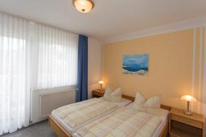 een slaapkamer met een bed met twee lampen en een raam bij Ferienwohnungen Beyer in Binz