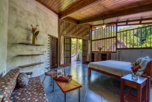 a bedroom with a bed and a couch in a room at Omega Tours Eco-Jungle Lodge in La Ceiba