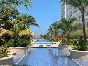 un complejo con piscina con palmeras y un edificio en Cartagena Morros 3 Playa, en Cartagena de Indias 24 fotos más