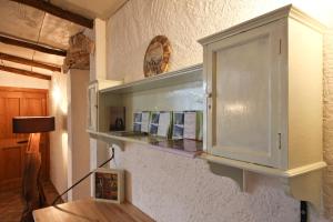 un armadietto bianco su un muro con mensola di Agriturismo Crotto Di Somana a Mandello del Lario