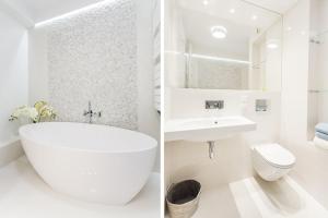 a white bathroom with a tub and a sink and a toilet at Apartament Sea Towers View in Gdynia