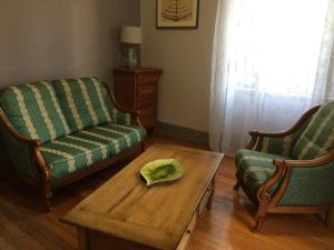 uma sala de estar com duas cadeiras e uma mesa de centro em Petite maison proche de Montbéliard em Sainte-Suzanne