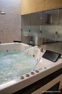 特林達德的住宿－Casa com 2 quartos e banheira de Hidromassagem，一间带浴缸和玻璃淋浴的浴室