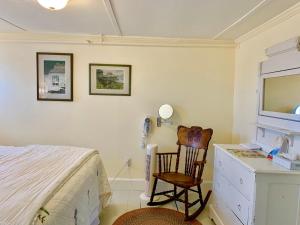 een slaapkamer met een bed, een bureau en een stoel bij Seaside Inn in Tenants Harbor