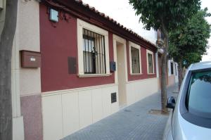 czerwono-biały budynek z oknem na ulicy w obiekcie Casa de David w Kordobie