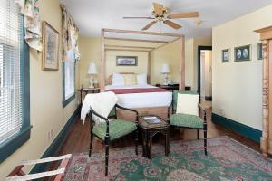 a bedroom with a bed and two chairs at Spencer House Inn in Saint Marys