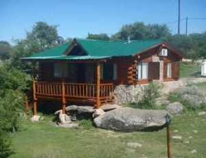 Cabaña de madera pequeña con techo verde en Aldea Serrana en Nono