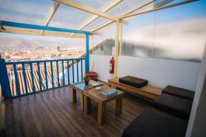 a room with a couch and a table on a balcony at La Casa de Mayte in Cusco