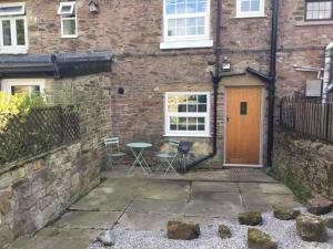 a brick building with a wooden door and a table at Country Retreat in Highpeak Junction