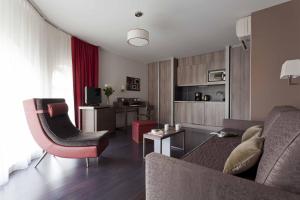 City Lofthotel Saint-Etienne في سانت إتيان: غرفة معيشة مع أريكة وطاولة