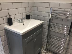 a bathroom with a sink and a white tiled wall at Country Retreat in Highpeak Junction +11 photos