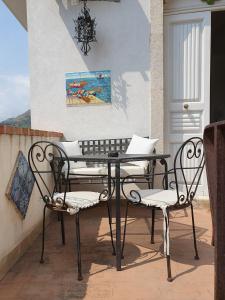 una mesa y 2 sillas sentadas en un balcón en Sciala', en Taormina