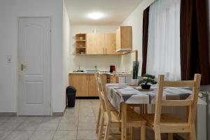 y cocina con mesa de comedor y sillas. en AqFel Airport Apartment en Vecsés