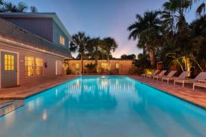 a large blue swimming pool next to a house at Buttonwood Cottage in Siesta Key