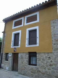 un edificio con tres ventanas y dos puertas en Casa Rural Jim Morrison, en Linares de Riofrío
