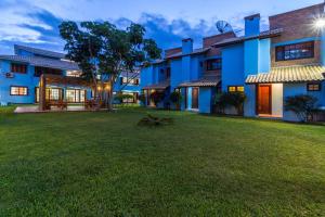 a large yard in front of a blue building at Condominio Vila Lila in Garopaba